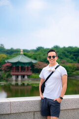 Young smiling Latino in casual outfit outside National Museum of Korea, Seoul, South Korea.