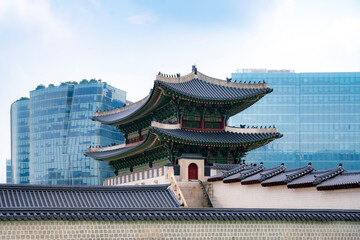Obraz premium Traditional Korean architecture at Gyeongbokgung Palace with modern skyscrapers in Seoul, South Korea.