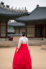 Unrecognizable Smiling young Latina in a traditional pink and white hanbok at Gyeongbokgung Palace, Seoul, South Korea.