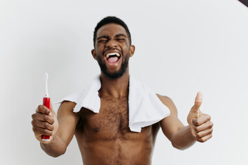 Shirtless man enthusiastically promoting dental hygiene with a toothbrush and thumbs up gesture in...