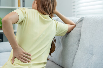 woman holding her lower back while and suffer from unbearable pain health and problems, chronic back pain, backache in office syndrome, scoliosis, herniated disc, muscle inflammation