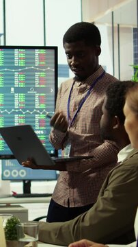 Vertical Video Diverse work team meeting in the boardroom to discuss corporate briefing reports and sharing innovative ideas. Employees plan effective marketing strategy for the upcoming quarter