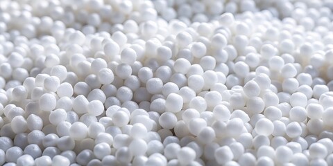 Detailed view of white plastic pellets, showcasing polymer granules arranged as a background, ideal for industrial applications and manufacturing processes. Versatile material for various uses.