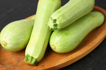 Fresh ripe zucchinis on dark table, closeup