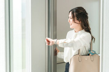 エレベーターホールから外に出かけるビジネスウーマン
