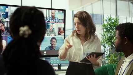 Employees attending an online remote videocall meeting with general manager, presenting project updates for efficiency. Work team ensuring strategic goals achievement in a boardroom. Camera B.