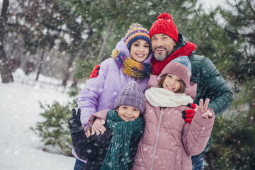 Photo of peaceful friendly full family embrace demonstrate v-sign enjoy snowfall december weather walk outside