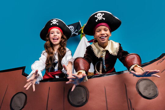 Photo of two small kids halloween pirate costume sail ship isolated on blue color background