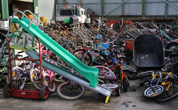 Recycling center. Assorted bicycles, slides, lawn mowers and wheelbarrows.