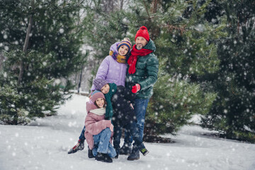 Full size portrait of four idyllic peaceful people embrace spend pastime walking snowy forest outside