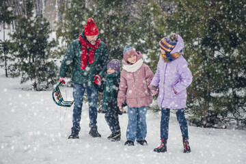Full body portrait of four friendly positive people hold arms walking snowy woods outdoors