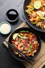Stir-fry sea food served on grey textured table, flat lay