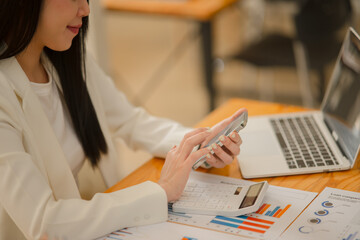 Asian business woman Use a calculator or laptop to make an accounting of income and expenses.  Monthly expenses