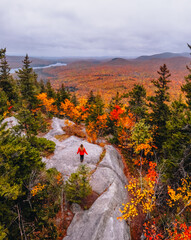 Epic Aerial View of Owl Head Mountain Vermont Girl in Orange Coat on Rock Overlooking Colorful Fall...