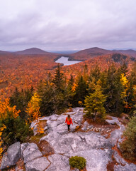 Epic Aerial View Beautiful Girl Owl Head Mountain Vermont Wide New England Fall Foliage Landscape Hiker in Orange Coat Overlooking Forest Autumn