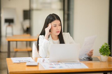 Obraz premium Asian business woman Stressed out and headache with paperwork at the office