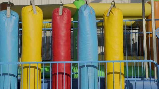This panning video shows a row of multi colored, hanging heavy bags.