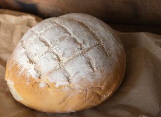 Close-up at 45 degrees of a loaf of bread on rustic paper.