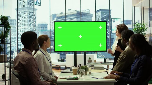 Diverse group of startup employees looking at green screen on an interactive board, meeting to discuss ideas and details to ensure organizational progress. Forecast affiliates in office. Camera B.