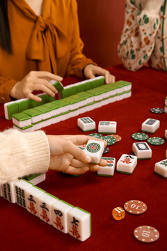 Woman in cheongsam playing mahjong(majiang), close-up, traditional Chinese mind game(Translation: mahjong terms, east, west, south, north, middle, fortune)