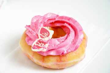 Donut with pink cream on a white background. Shallow dof.