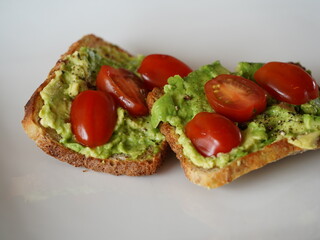 Delicious smashed avocado on toast on a white plate