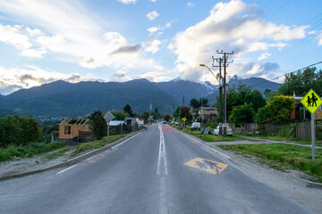 Fototapeta premium Empty road leading to the mountains in a cloudy day in a small village in chile