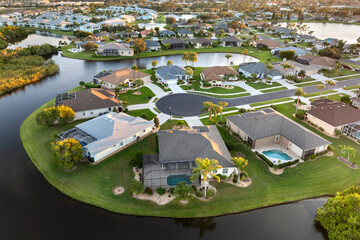 Waterfront single family homes in Florida residential area at sunset. Real estate development in American suburbs