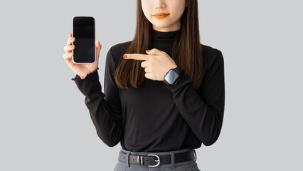 スマホを指差す若いビジネスウーマン