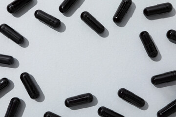 Activated carbon in the form of tablets, on a light background.