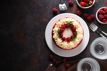 Red velvet cake, berries, glass and towel on gray background, space for text