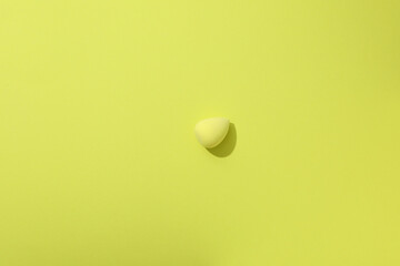 Yellow makeup sponge on a yellow background