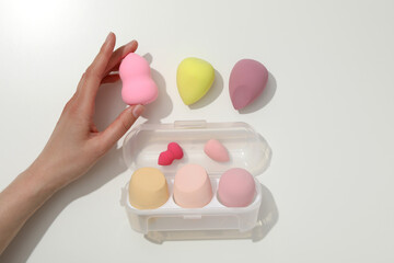 Makeup sponges in a plastic case on a light background