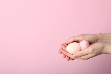 Makeup sponges in hand on pink background
