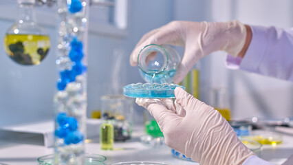 Laboratory scene photo was taken from front view, the scientist holds glass erlenmeyer flask and...