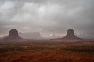 Monument Valley with mist with sandstone buttes seen on Navajo land in Arizona