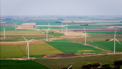 Panoramic view of a wind energy park surrounded by vast fields of crops.