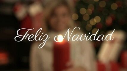 Feliz Navidad text animation over person holding red candle with Christmas decorations - Powered by Adobe