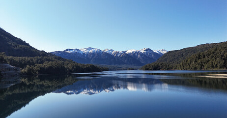 Fantastic view of Correntoso Lake with snow-capped mountains reflected in its calm waters.