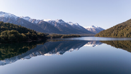 Correntoso Lake with mountains reflecting in the water, creating a natural frame along the Ruta de los Siete Lagos in Argentine Patagonia.