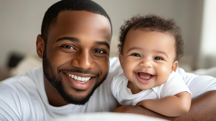 A joyful father shares a sunny moment with his smiling baby son, showcasing the beauty of family love and connection.