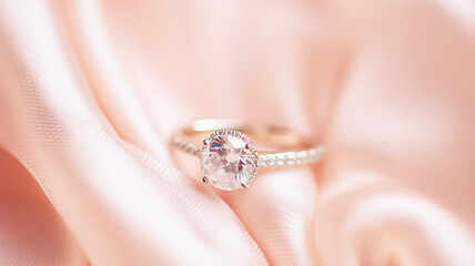 Jewellery, proposal and holiday gift, diamond engagement ring on pink silk fabric, symbol of love, romance and commitment inspiration