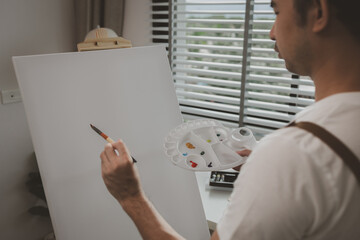 an artist is sitting in his own painting studio with his various painting tools, which is canvas, palette, watercolors, oils, poster colors , artistic, painter, colours, creativity, skills