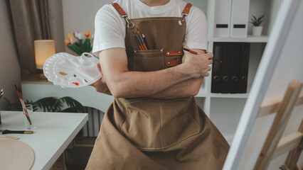 a painter is in his painting studio, a rising male artist is focusing on creating his best...