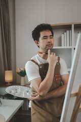 a painter is in his painting studio, a rising male artist is focusing on creating his best...