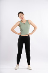 Full body image of young Asian girl wearing sports outfit and posing on white background