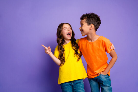 Photo of charming two little children laughing point empty space wear trendy orange yellow outfit isolated on violet color background - Powered by Adobe