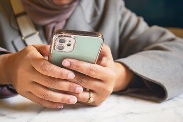 Person Holding Smartphone in Cozy Caf Setting