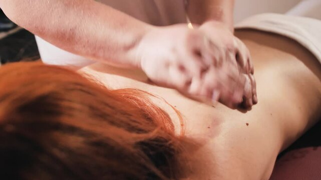 Relaxing massage therapy session with a therapist massaging a client's back. The scene captures peaceful, soothing care for stress relief and relaxation. Close-up