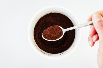 pantry staple close-up, spoonful of ground coffee over clear glass jar shot from above